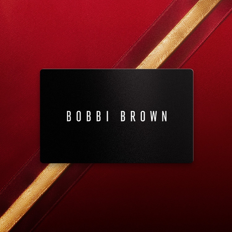 Animation of Bobbi Brown gift cards stacking in a spiral, in front of a red, festive background